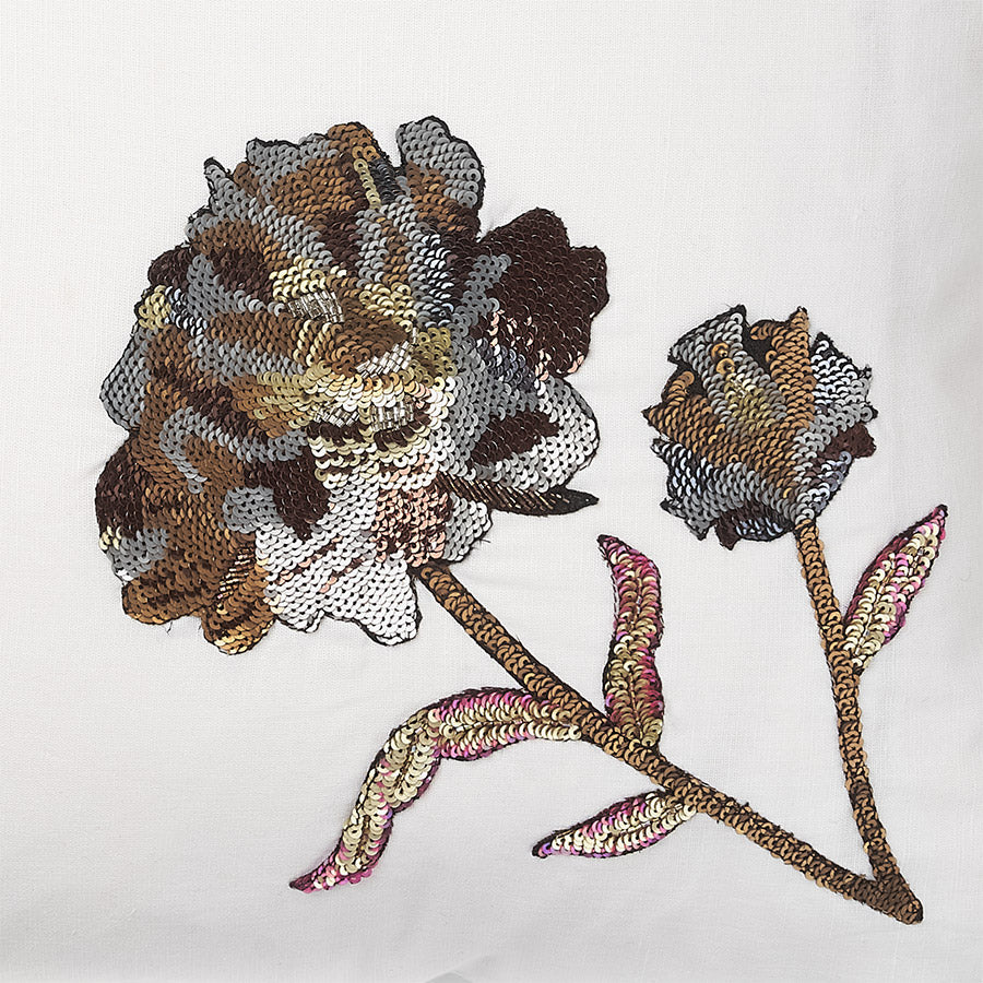 detail of a White linen luxury cushion with sequin flowers